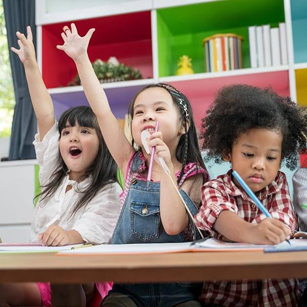 Young school girls responding to teacher in lesson time